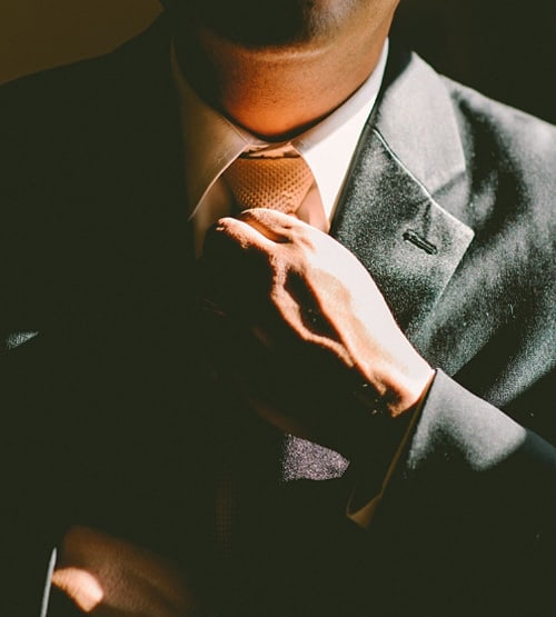 man fixing his tie